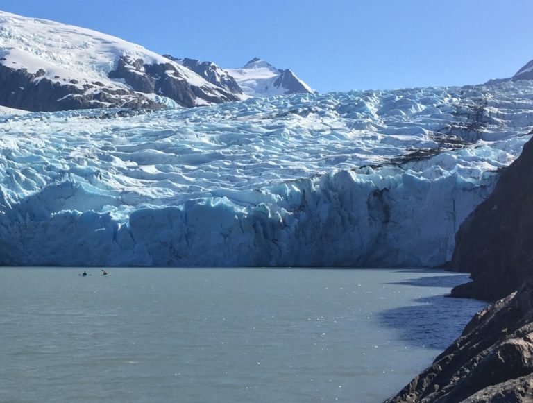 Two tiny Kayakers at terminus of Portage Glacier, Alaska. Photo Grant Gibbs